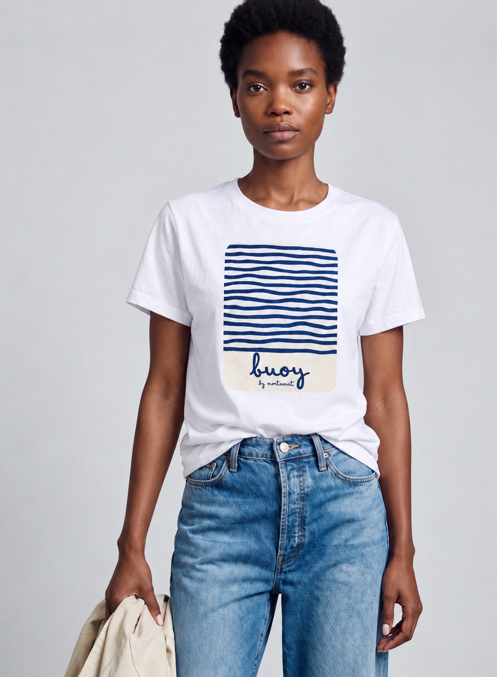 Model wearing a white Buoy graphic T-shirt with blue jeans against a light gray background.
